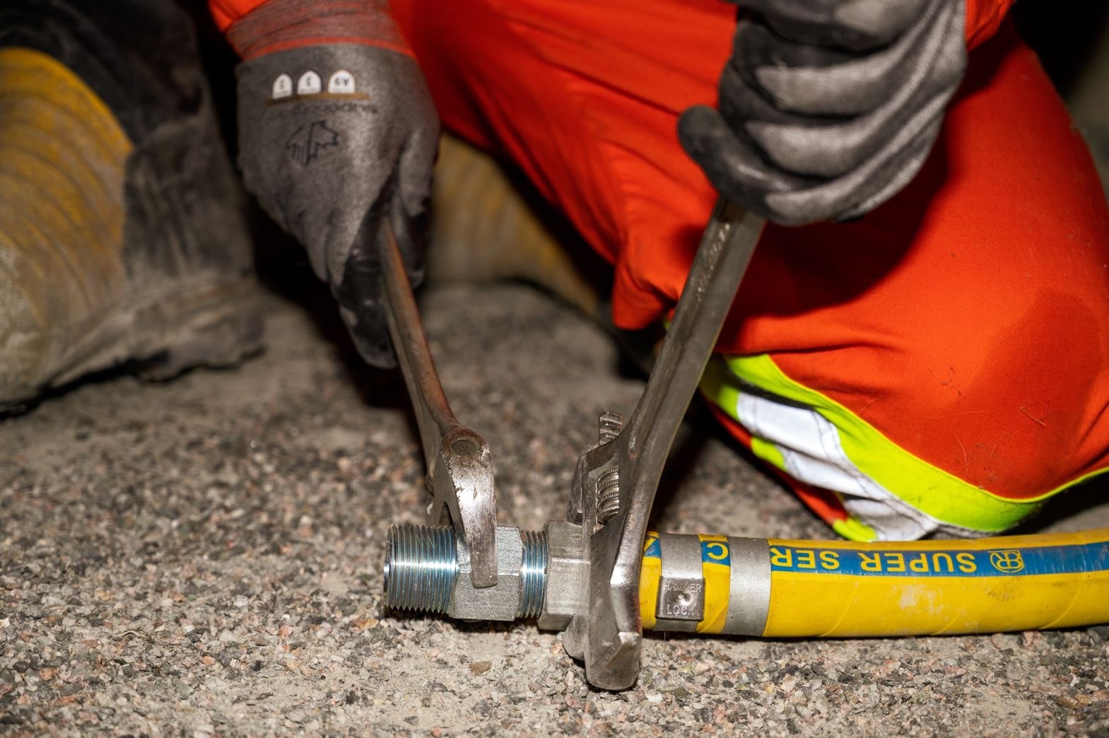 Technician using a wrench on the Hexa Hex Nipple fitted to a yellow hose